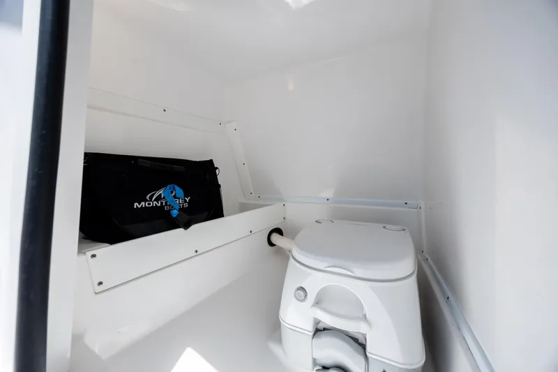 Slide: The Image of 2024 Monterey M-45 boat interior with portable toilet and storage bag. - 24