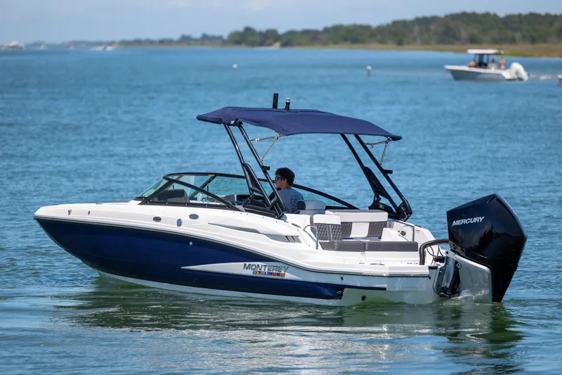 Slide: The Image of 2024 Monterey M-45 boat cruising on a calm lake with a Mercury engine. - 3