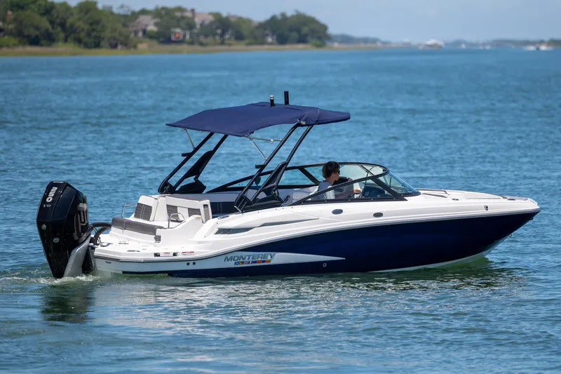 Slide: The Image of 2024 Monterey M-45 boat cruising on a serene lake with a blue canopy. - 5