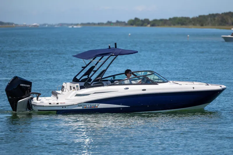 Slide: The Image of 2024 Monterey M-45 boat cruising on a serene lake with a Mercury engine. - 6