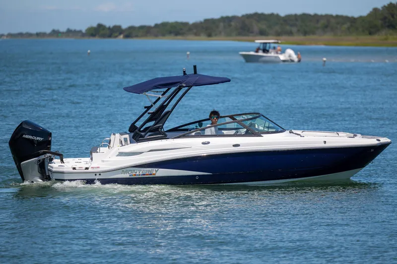 Slide: The Image of 2024 Monterey M-45 boat cruising on a serene lake with a Mercury engine. - 7