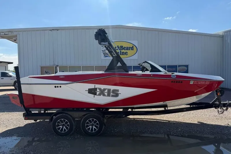 Slide: The Image of Red and white 2022 Axis T220 boat on trailer outside dealership. - 1
