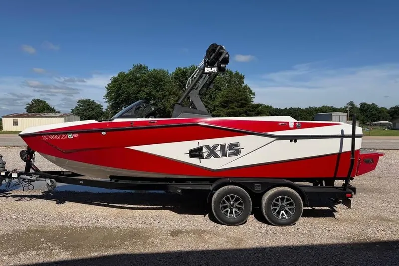 Slide: The Image of 2022 Axis T220 boat in red and white on a trailer, parked outdoors. - 3