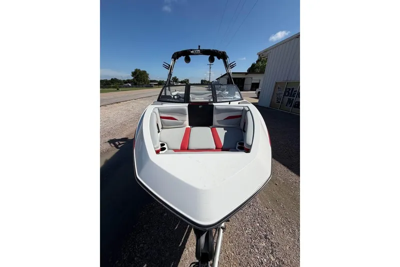 Slide: The Image of 2022 Axis T220 boat with red and gray interior, parked outdoors. - 5