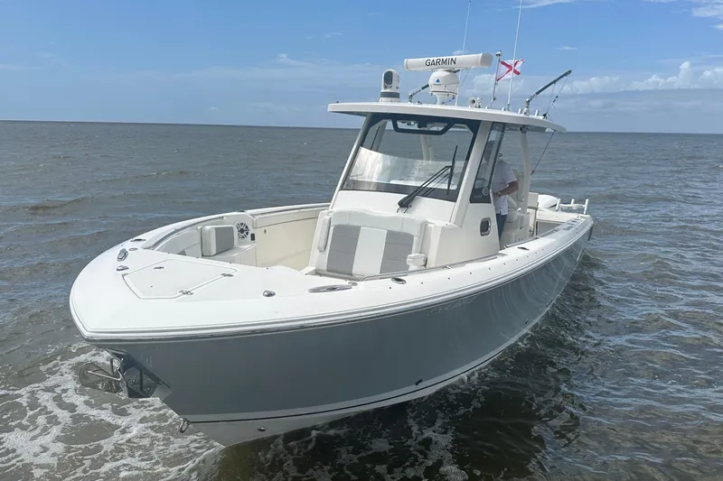 The Image of 2021 Pursuit S 328 Sport boat on open water under clear sky. - 0