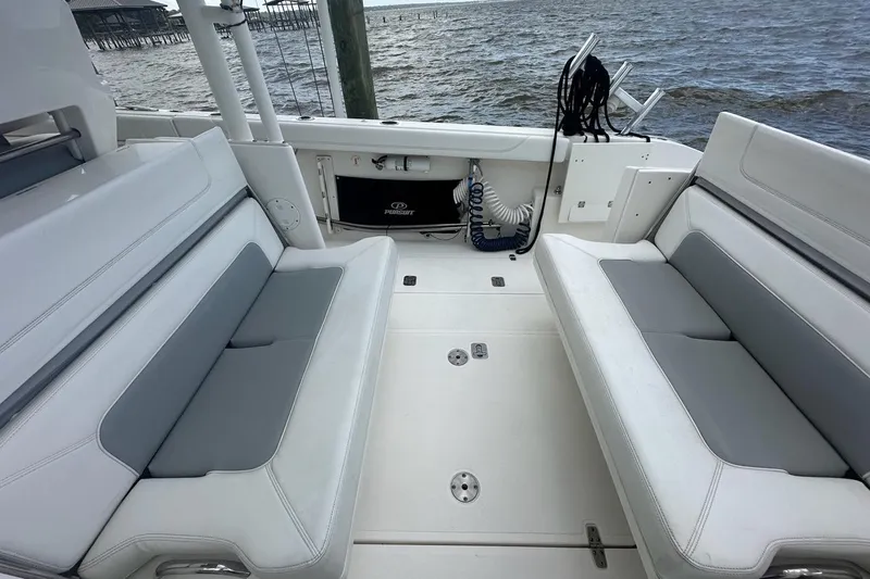 Slide: The Image of 2021 Pursuit S 328 Sport boat interior with cushioned seating and ocean view. - 19