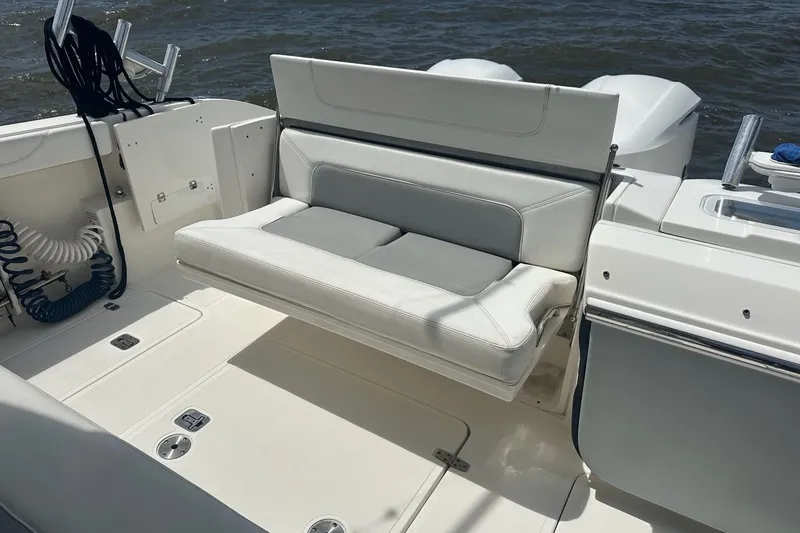 Slide: The Image of 2021 Pursuit S 328 Sport boat interior with cushioned seating and storage compartments. - 21