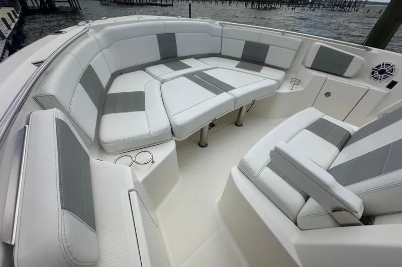 Slide: The Image of Luxurious seating area on a 2021 Pursuit S 328 Sport boat, featuring white and gray upholstery. - 24