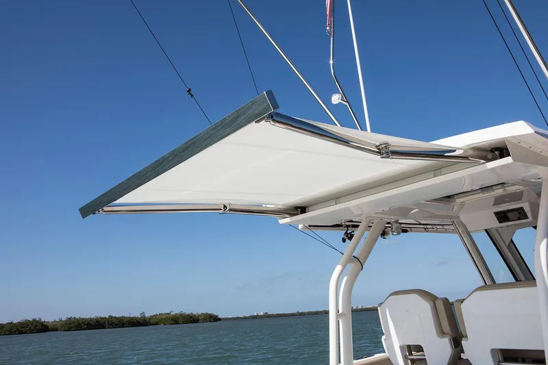 Slide: The Image of Manufacturer Provided Image: 2021 Pursuit S 328 Sport boat with extended sunshade over water. - 47