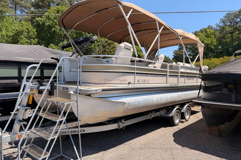 The Image of 2006 Premier 250 Grand Majestic RE pontoon boat on trailer with canopy, parked outdoors. - 1