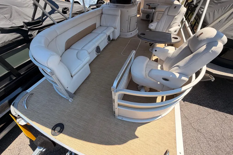 Slide: The Image of 2006 Premier 250 Grand Majestic RE pontoon boat interior with plush seating and table. - 2