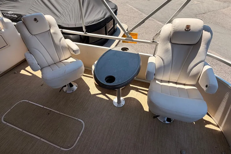 Slide: The Image of Interior of 2006 Premier 250 Grand Majestic RE with two white captain chairs and a small table. - 4