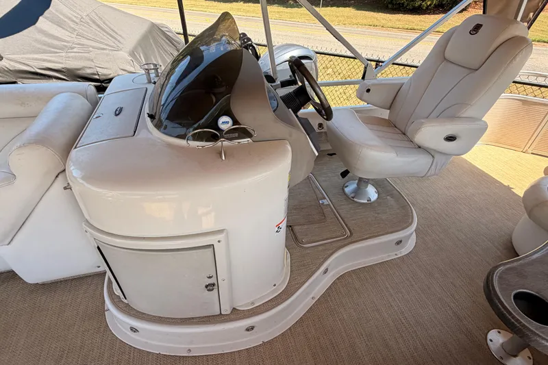 Slide: The Image of Captain's helm of a 2006 Premier 250 Grand Majestic RE pontoon boat with plush seating. - 6