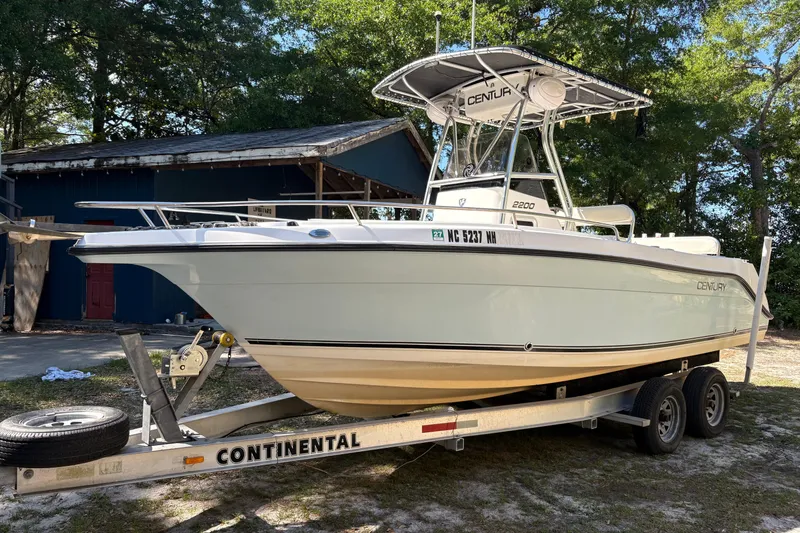 The Image of 2005 Century 2200 Center Console boat on trailer, parked outdoors. - 0