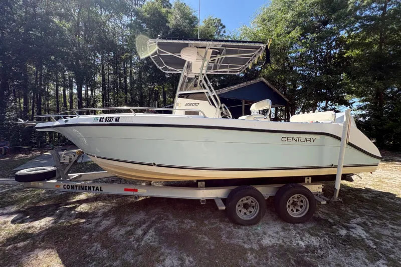 Slide: The Image of 2005 Century 2200 Center Console boat on trailer, surrounded by trees. - 1
