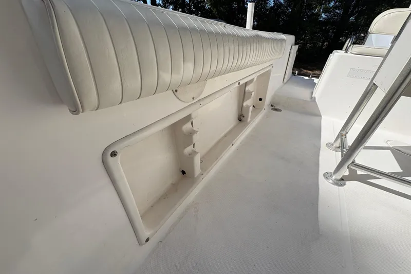 Slide: The Image of 2005 Century 2200 Center Console boat interior with white seating and storage compartment. - 20