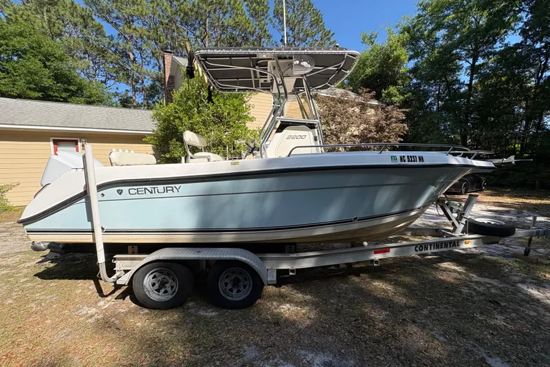 Slide: The Image of 2005 Century 2200 Center Console boat on trailer, parked outdoors. - 5