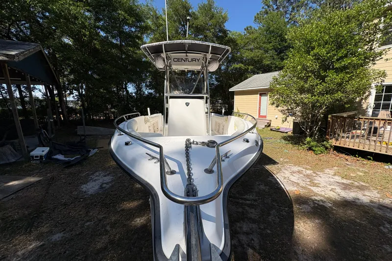 Slide: The Image of 2005 Century 2200 Center Console boat parked outdoors near trees and a house. - 8