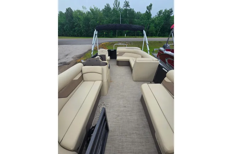 Slide: The Image of 2019 Crest I L Cp2 pontoon boat with beige seating and canopy, parked near trees. - 9