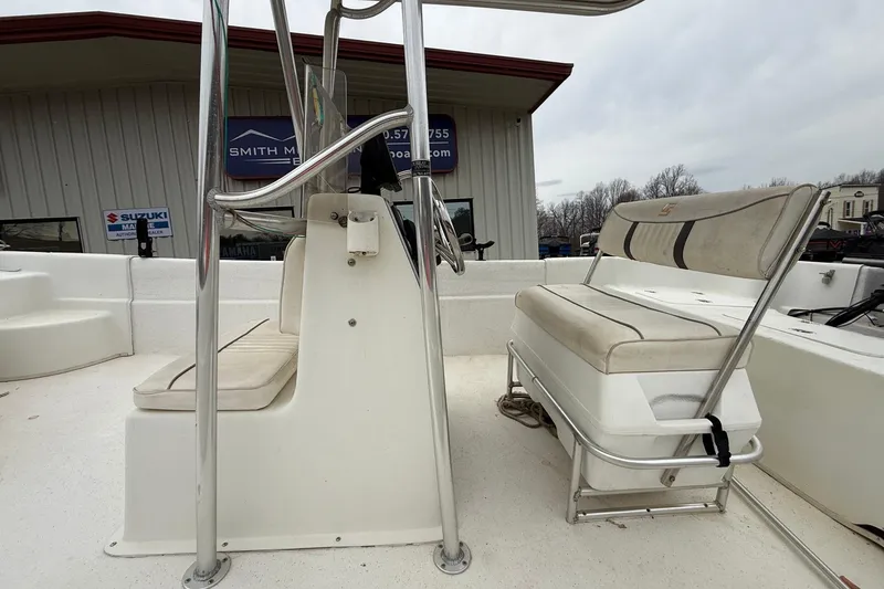 Slide: The Image of 2008 Carolina Skiff 218 DLV boat interior with seating and console, outside dealership. - 5