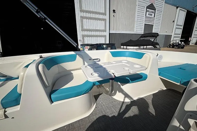 Slide: The Image of 2022 Bayliner Element E18 boat interior with teal seating and a central table. - 13