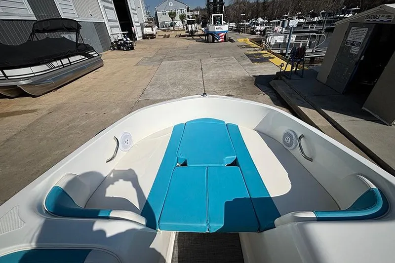 Slide: The Image of 2022 Bayliner Element E18 boat with blue seating, docked at a marina. - 15