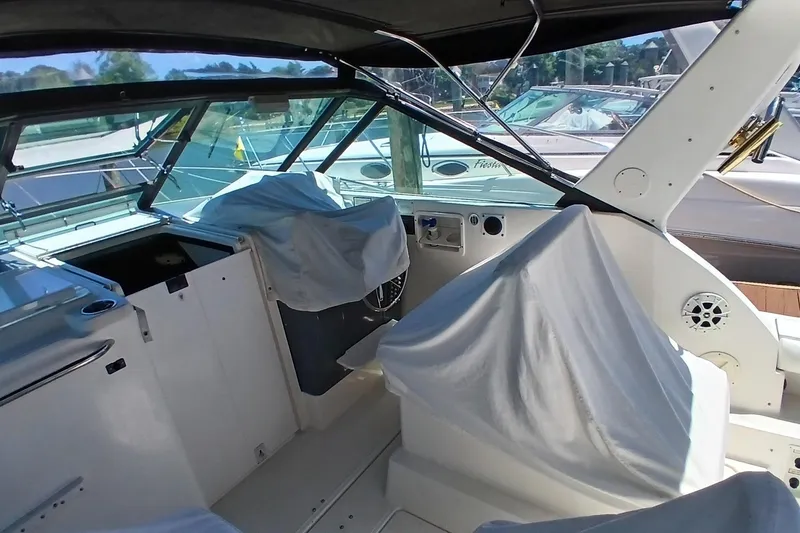 Slide: The Image of 2001 Tiara Yachts 2900 Open interior with covered seating and helm, docked at marina. - 10