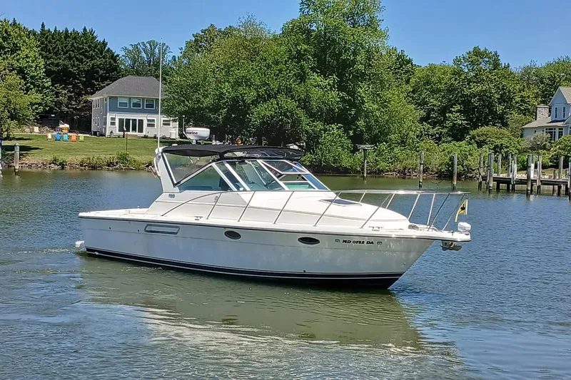 Slide: The Image of 2001 Tiara Yachts 2900 Open cruising on a serene lake near waterfront homes. - 2