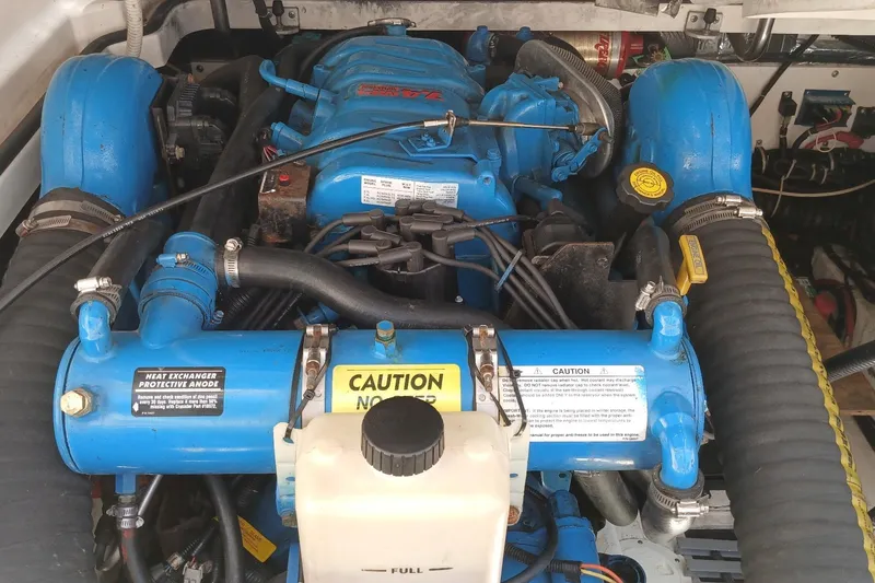 Slide: The Image of Engine compartment of a 2001 Tiara Yachts 2900 Open, featuring blue components and caution labels. - 27