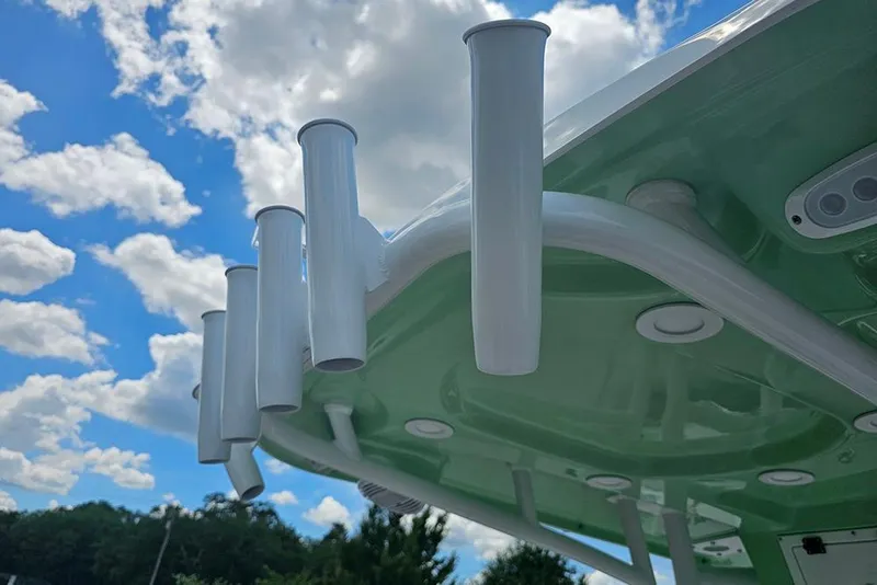 Slide: The Image of Rod holders on a 2026 Sea Pro 202 Center Console boat under a blue sky. - 13