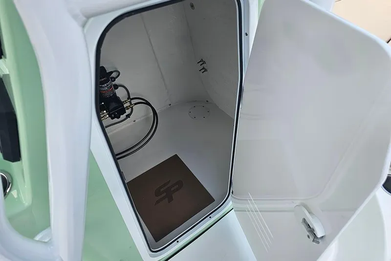 Slide: The Image of 2026 Sea Pro 202 Center Console storage compartment with open door and visible equipment. - 15