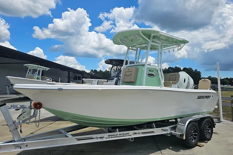 Slide: The Image of 2026 Sea Pro 202 Center Console boat on trailer under a partly cloudy sky. - 2