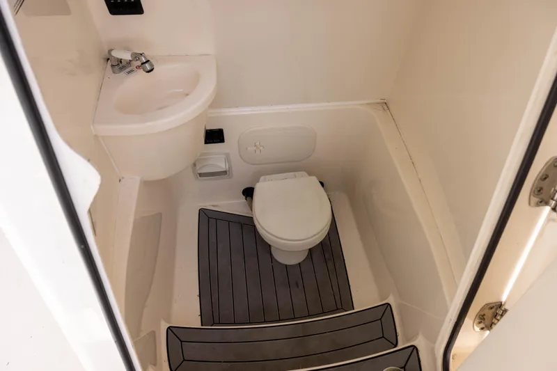 Slide: The Image of 2020 Cobia 262 Center Console boat bathroom with sink and toilet. - 11