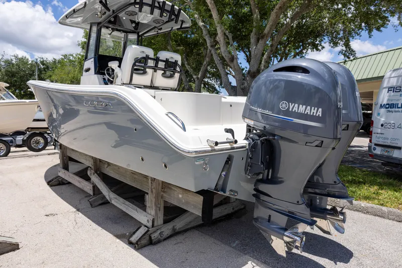 Slide: The Image of 2020 Cobia 262 Center Console boat with Yamaha engines on display outdoors. - 2