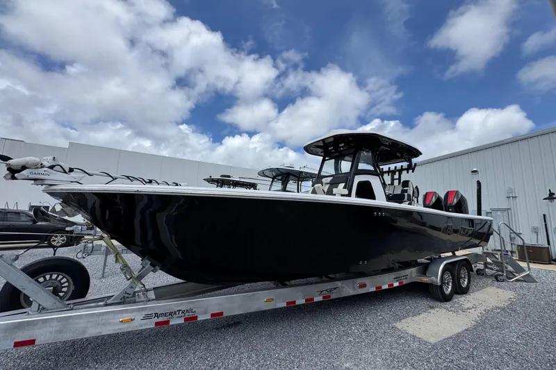 The Image of 2024 Tidewater 3100 Carolina Bay boat on trailer, parked outdoors under cloudy sky. - 1