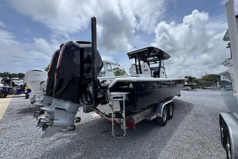 Slide: The Image of 2024 Tidewater 3100 Carolina Bay boat on trailer, featuring dual outboard motors. - 11