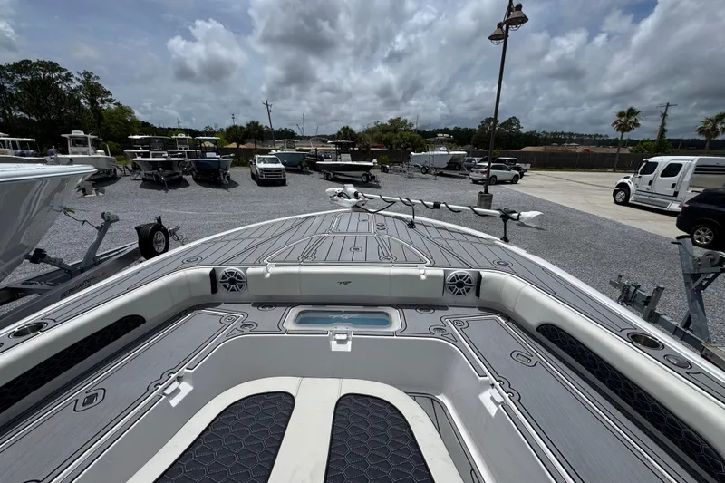 Slide: The Image of 2024 Tidewater 3100 Carolina Bay boat, showcasing spacious deck and modern design at a marina. - 13