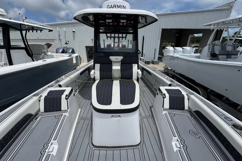 Slide: The Image of 2024 Tidewater 3100 Carolina Bay boat with sleek seating and modern design at a marina. - 18