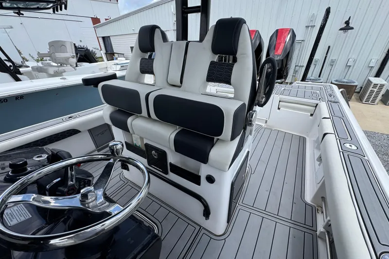 Slide: The Image of 2024 Tidewater 3100 Carolina Bay boat interior with steering wheel and seating. - 21