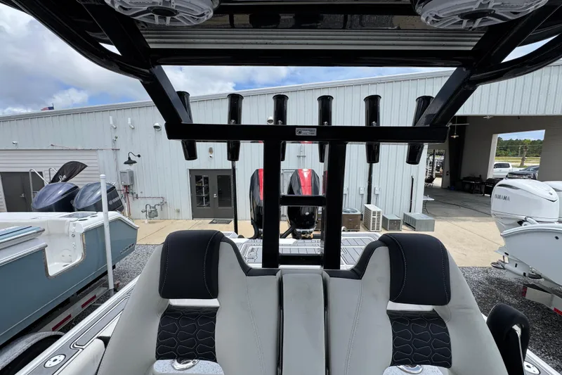 Slide: The Image of 2024 Tidewater 3100 Carolina Bay boat interior with rod holders and seating, docked at a marina. - 23