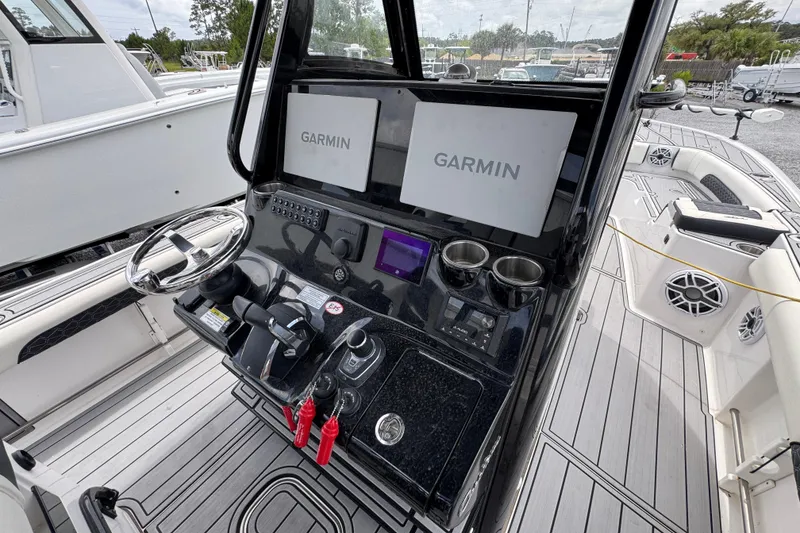 Slide: The Image of 2024 Tidewater 3100 Carolina Bay boat dashboard with dual Garmin displays and modern controls. - 27