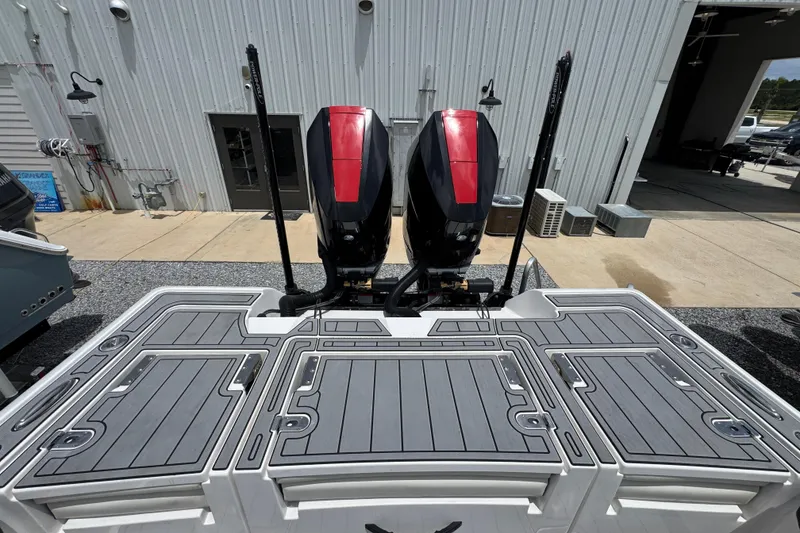 Slide: The Image of 2024 Tidewater 3100 Carolina Bay boat with dual outboard motors at a marina. - 33