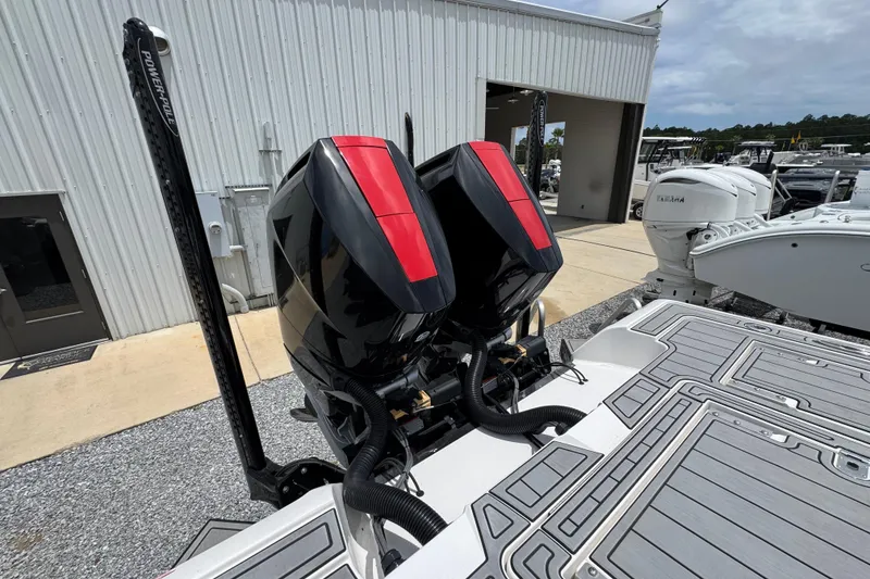 Slide: The Image of 2024 Tidewater 3100 Carolina Bay boat with dual outboard engines at a marina. - 35