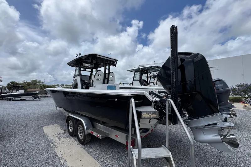 Slide: The Image of 2024 Tidewater 3100 Carolina Bay boat on trailer, featuring dual outboard engines. - 7