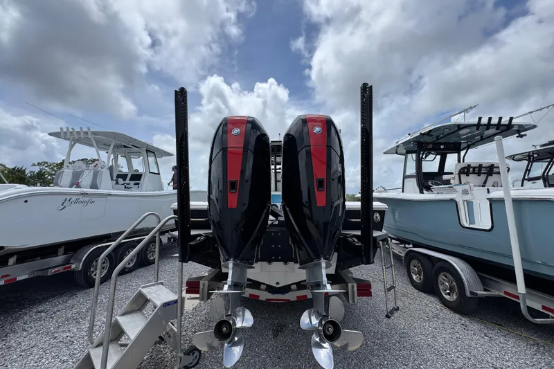 Slide: The Image of 2024 Tidewater 3100 Carolina Bay boat with dual outboard motors, parked on gravel. - 9