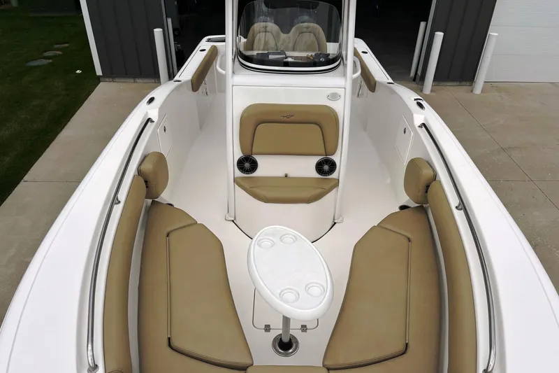 Slide: The Image of 2016 Tidewater 252 CC Adventure boat interior with tan seating and white table. - 10