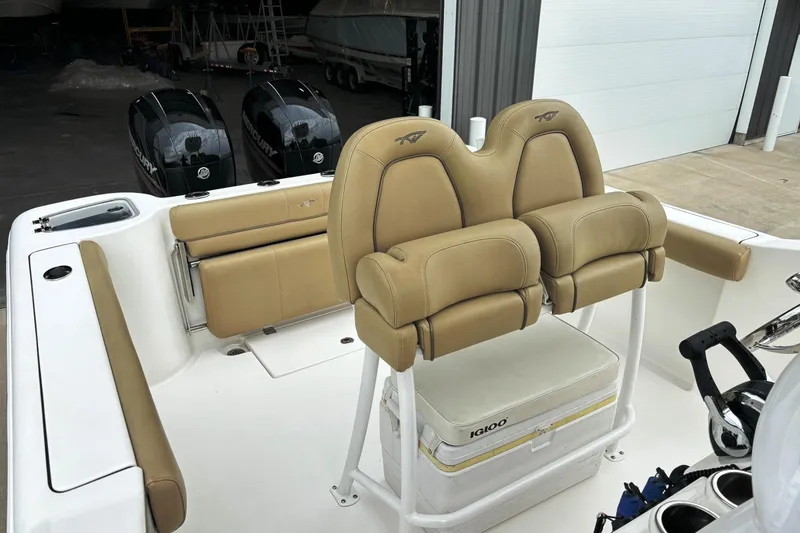 Slide: The Image of 2016 Tidewater 252 CC Adventure boat interior with tan seating and dual Mercury engines. - 15