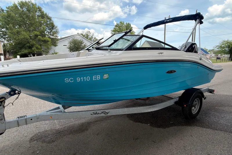 The Image of 2021 Sea Ray SPX 190 boat on trailer, vibrant blue hull, parked outdoors. - 0