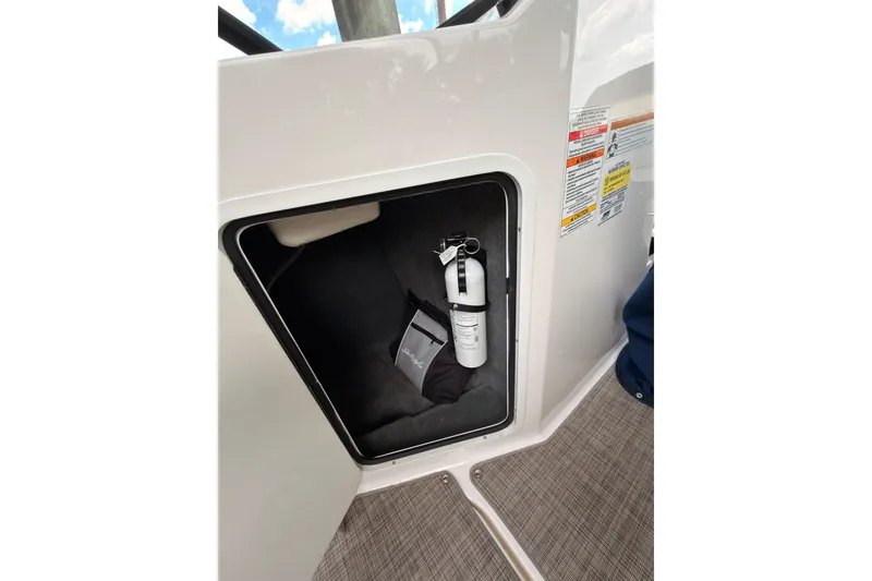 Slide: The Image of Storage compartment in 2021 Sea Ray SPX 190 boat with fire extinguisher and bag. - 29
