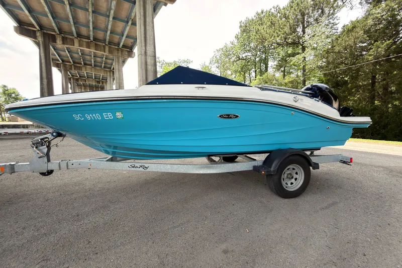 Slide: The Image of 2021 Sea Ray SPX 190 boat on trailer under bridge, vibrant blue hull. - 3